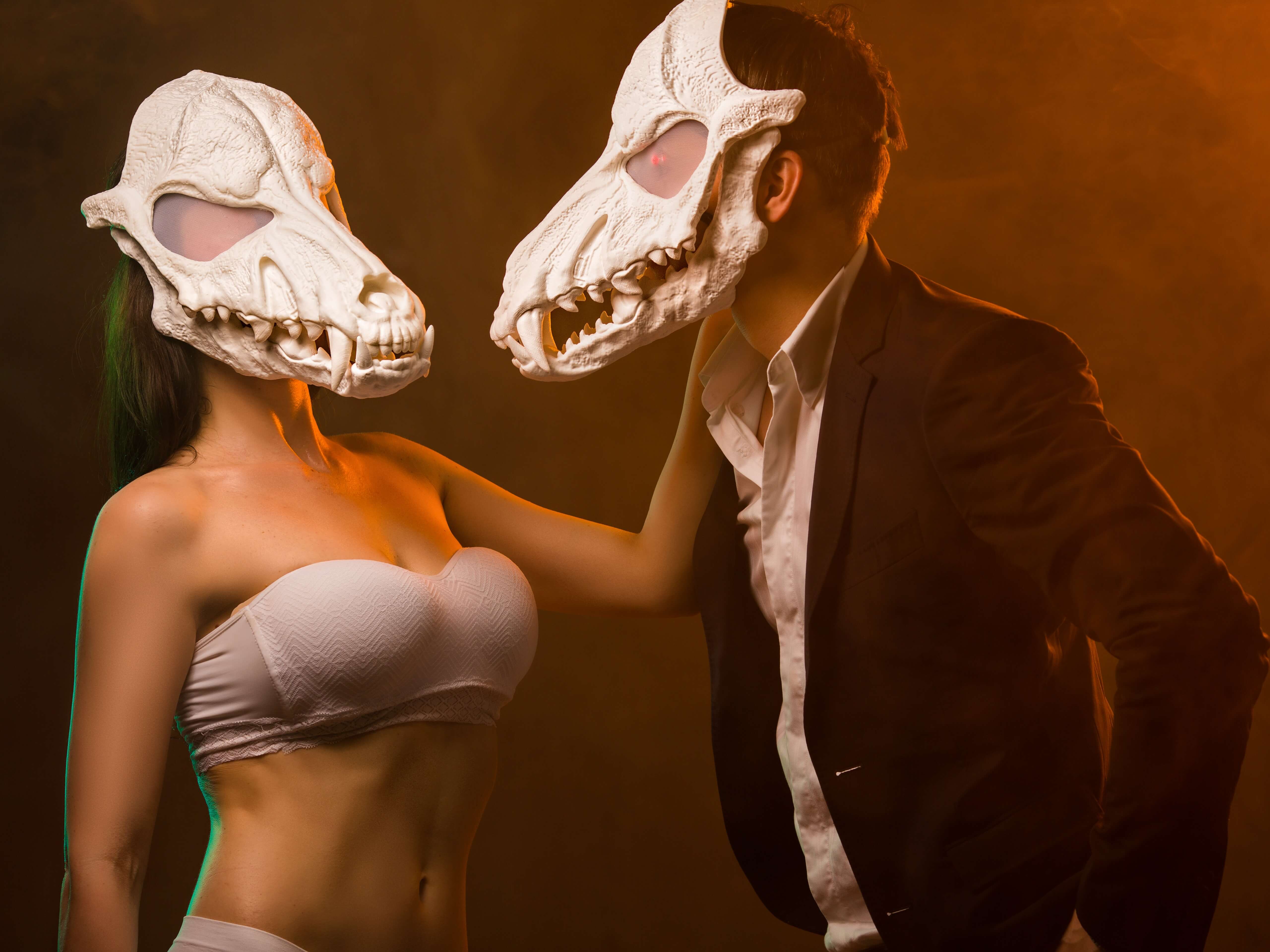White wolf skull masks cosplay couple portrait - close up with dramatic lighting